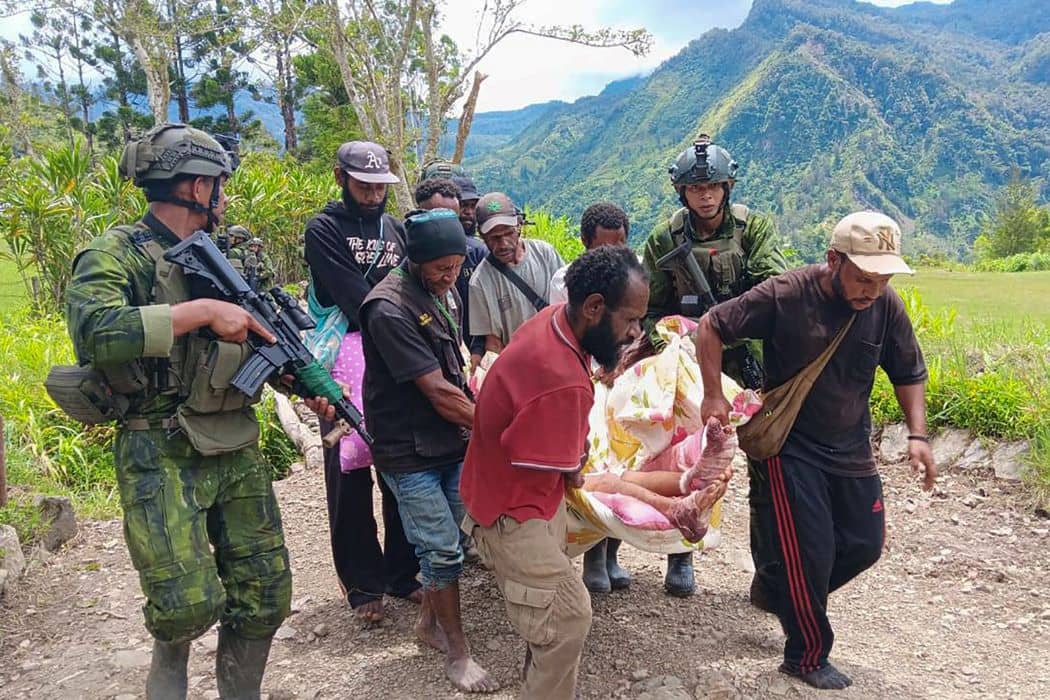 Personel TNI mengawal warga mengevakuasi jenazah korban serangan KKB di Kabupaten Yahukimo, Papua Pegunungan. Dokumentasi Antara