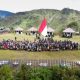 Orang asli Papua (OAP) mengibarkan bendera Merah Putih saat memperingati Hari Integrasi Papua ke Indonesia, yang dirayakan setiap 1 Mei, di Bukit Zaitun, Distrik Mulia, Puncak Jaya. Istimewa