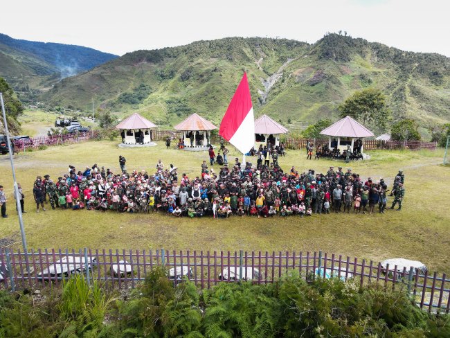 Orang asli Papua (OAP) mengibarkan bendera Merah Putih saat memperingati Hari Integrasi Papua ke Indonesia, yang dirayakan setiap 1 Mei, di Bukit Zaitun, Distrik Mulia, Puncak Jaya. Istimewa