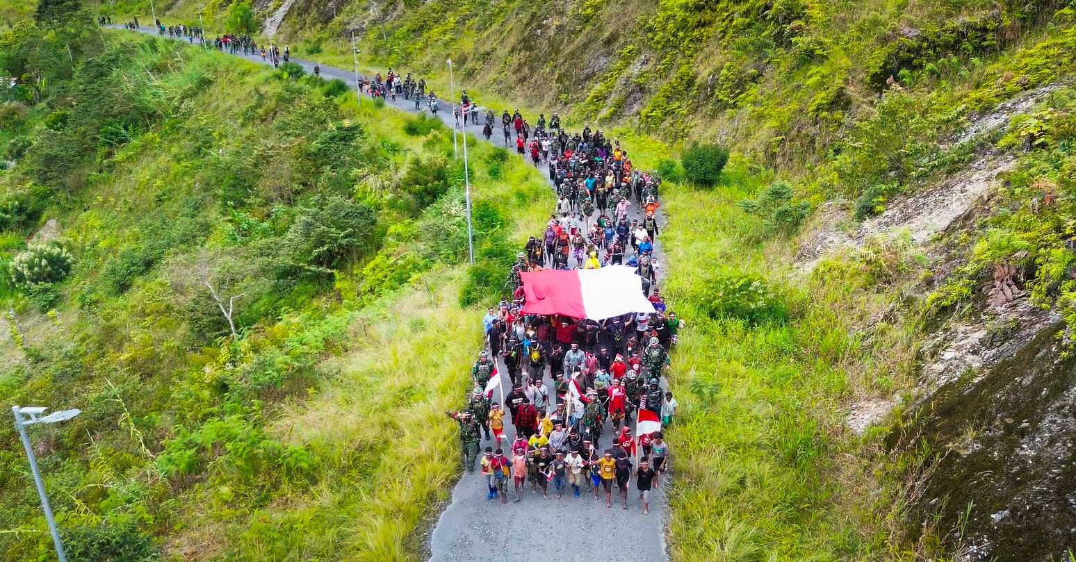 Orang asli Papua (OAP) membentangkan bendera Merah Putih dalam sebuah arak-arakan saat memperingati Hari Integrasi Papua ke Indonesia, yang dirayakan setiap 1 Mei, di Bukit Zaitun, Distrik Mulia, Puncak Jaya. Istimewa