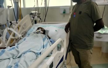 Anggota Lembaga Masyarakat Adat (LMA) Kabupaten Mimika, Jerry Alom, menjenguk Apeliu Magai, warga sipil korban kontak tembak pada 8 Mei 2026 antara aparat keamanan dan kelompok separatis teroris Papua di kawasan Mile 68 Tembagapura, Papua Tengah, di RSUD Mimika pada Selasa (12/5/2026). Dok. pribadi